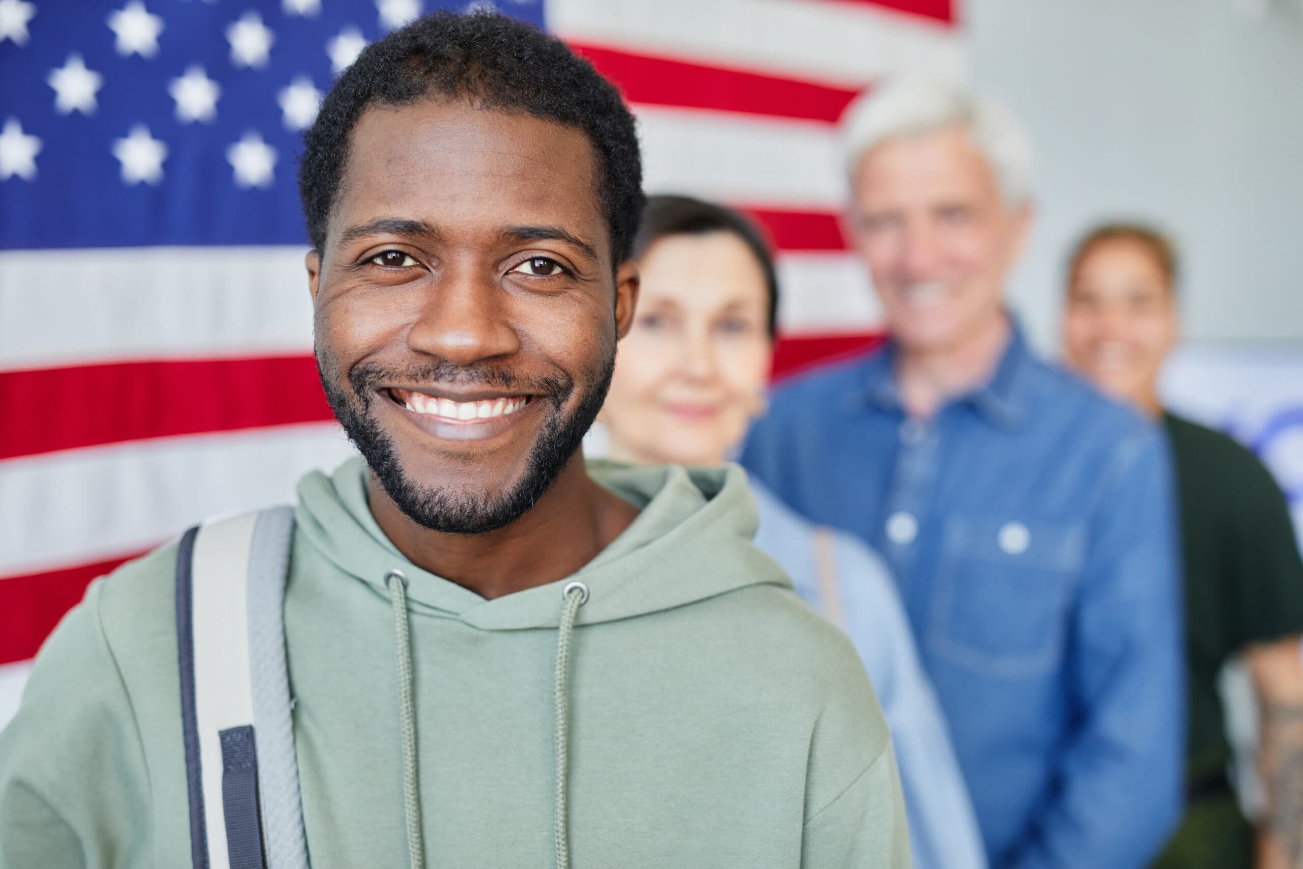 Man smiling in front of American flag - immigration DNA testing